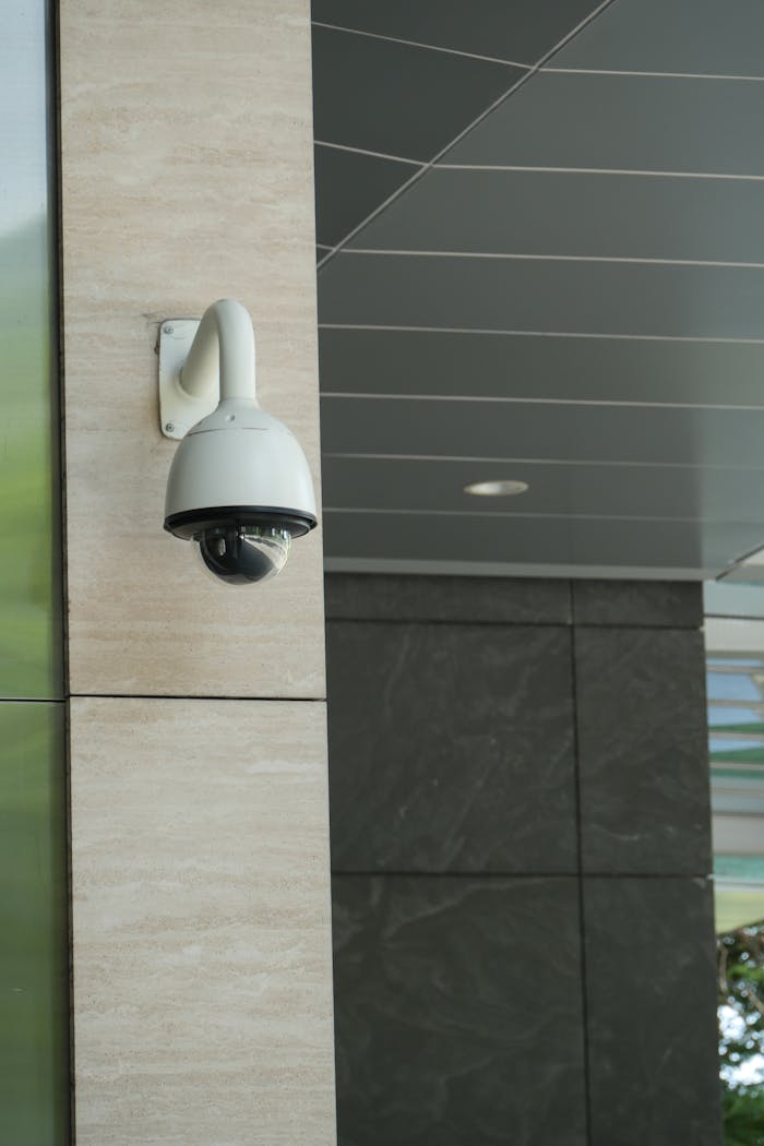 about-04 Close-up of a mounted security camera on a modern building's exterior.