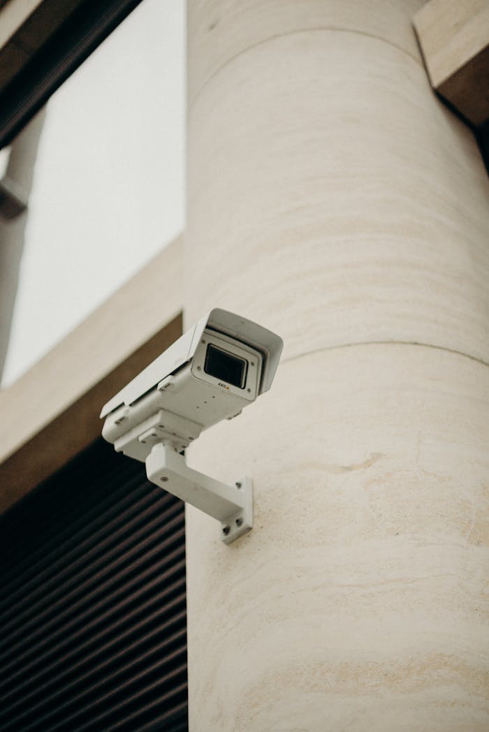 about-02 Close-up of a CCTV camera on a concrete building, symbolizing security and technology.